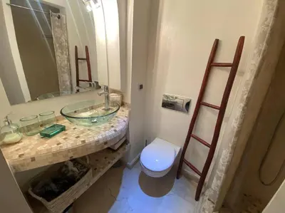 a bathroom with a sink and a toilet and a mirror at Bel appartement en centre-ville avec piscine in Marrakech