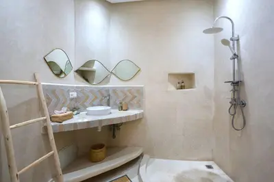 a bathroom with a shower and a sink and mirror at Riad El Khir en centre ville rooftop et bassin in Marrakech