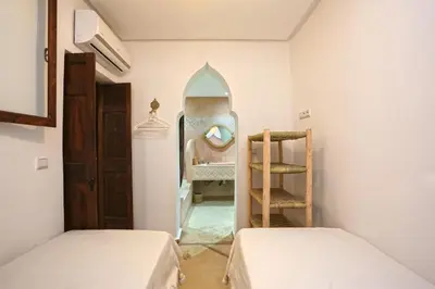 a small room with two beds and a mirror at Riad El Khir en centre ville rooftop et bassin in Marrakech