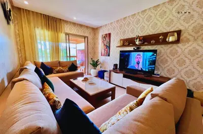 a living room with a couch and a tv at Luxurious Stay at Prestigia Golf Marrakech with Golf Course, Pool, and Breathtaking Atlas Mountains View in Marrakech