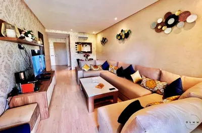 a living room with a couch and a tv at Luxurious Stay at Prestigia Golf Marrakech with Golf Course, Pool, and Breathtaking Atlas Mountains View in Marrakech
