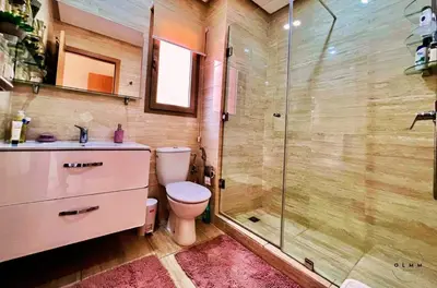 a bathroom with a toilet and a glass shower at Luxurious Stay at Prestigia Golf Marrakech with Golf Course, Pool, and Breathtaking Atlas Mountains View in Marrakech
