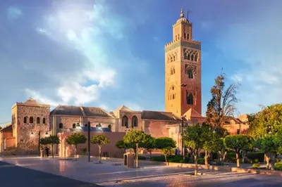 a large building with a tower with a clock at Sunny terrace & comfy beds in Marrakech in Marrakech