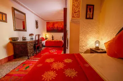 a bedroom with two beds and a desk in it at Riad Dombaraka in Marrakech