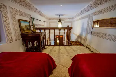 a large room with two beds and a staircase at Riad Dombaraka in Marrakech