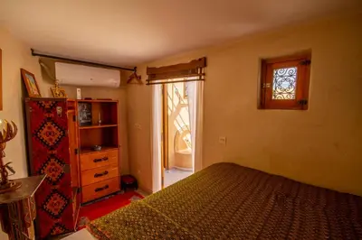 a bedroom with a bed and a dresser and a window at Riad Dombaraka in Marrakech