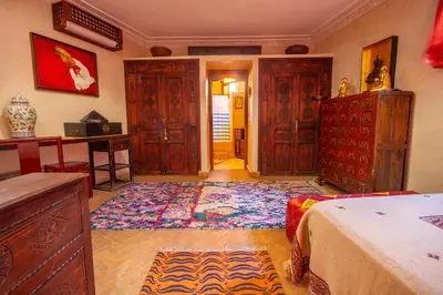 a living room with wooden furniture and a rug at Riad Dombaraka in Marrakech