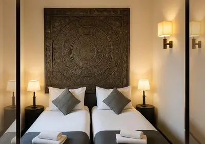 two beds in a room with two lamps at Vizir appart A112 in Marrakech