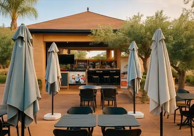 a group of tables and umbrellas in front of a kitchen at Vizir appart A112 in Marrakech