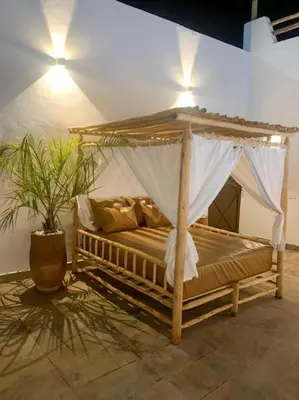 a bed with a canopy in a room with a plant at Magnifique villa sans vis-à-vis • Marrakech in Marrakech