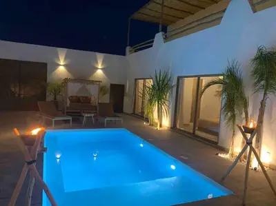 a large swimming pool in a backyard at night at Magnifique villa sans vis-à-vis • Marrakech in Marrakech