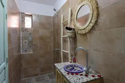 a bathroom with a sink and a mirror and a shower at RIAD CHOUKRI in Marrakech