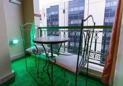 a small table and chairs on a balcony at Gueliz Great Apt with Pool Self Check In 24 7 Security in Marrakech