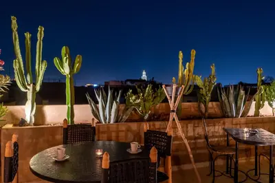 a patio with two tables and chairs and cactus at Riad Celema & Spa in Marrakech