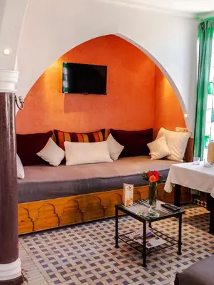 a couch in a living room with a tv on a wall at Penthouse Marrakech in Marrakech
