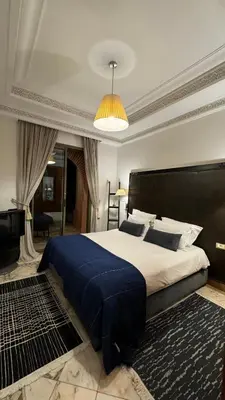 a bedroom with a large bed with a blue blanket at Très joli Appart à la palmeraie coup de cœur in Marrakech