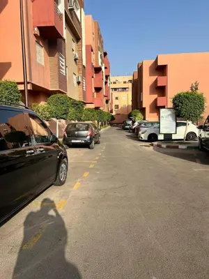 a shadow of a person walking down a street with cars at Marrakesh manara in Marrakech