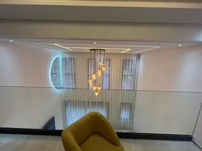 a yellow chair in a room with a chandelier at Menara Duplex in Marrakech
