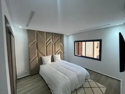 a bedroom with a white bed and a window at Menara Duplex in Marrakech