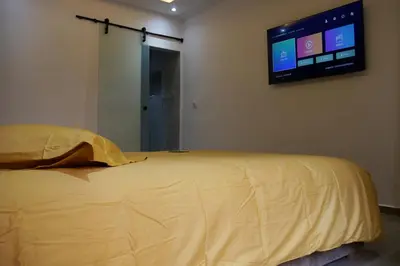 a bedroom with a bed with a television on the wall at Menara Duplex in Marrakech
