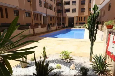 a swimming pool in the middle of a building with plants at Menara Duplex in Marrakech