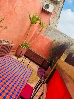 a table and chairs sitting on a patio with plants at RIAD ALGHANI in Marrakech