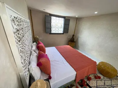 a bedroom with a bed with pillows and a window at Oasis Merasi Marrakech in Marrakech