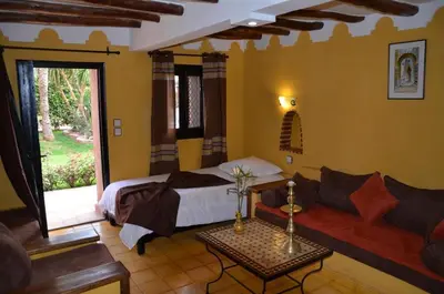a bedroom with a bed and a couch and a table at GREEN HOUSE in Marrakech