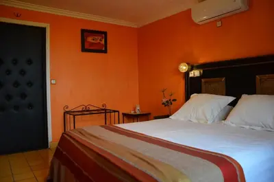 a bedroom with a large bed with an orange wall at GREEN HOUSE in Marrakech