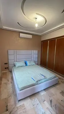 a bedroom with a bed with a ceiling at Appartement Bellevue in Marrakech