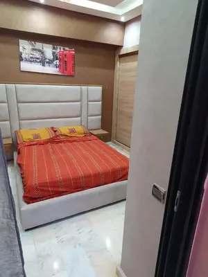 a bedroom with a bed with red and yellow sheets at Appartement Bellevue in Marrakech