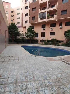 a swimming pool in front of a building at Appartement Bellevue in Marrakech