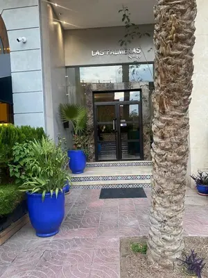 a building with a palm tree in front of a building at stylish appartment heart of gueliz in Marrakech