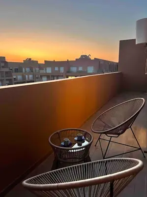 two chairs and a table on a balcony at NOUR appartement in Marrakech