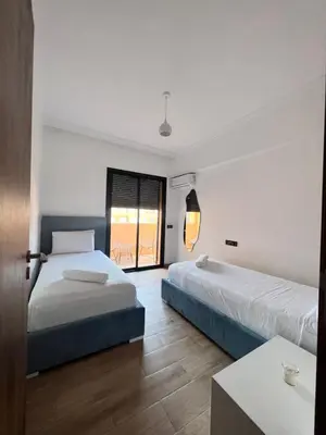 a hotel room with two beds and a window at NOUR appartement in Marrakech