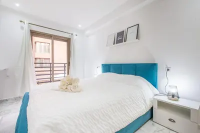 a bedroom with a blue and white bed and a window at NEW! Chic Plein Gueliz, parking, Iptv in Marrakech