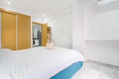 a white bedroom with a large bed and a mirror at NEW! Chic Plein Gueliz, parking, Iptv in Marrakech