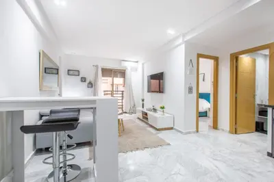 a white room with a desk and a bedroom at NEW! Chic Plein Gueliz, parking, Iptv in Marrakech