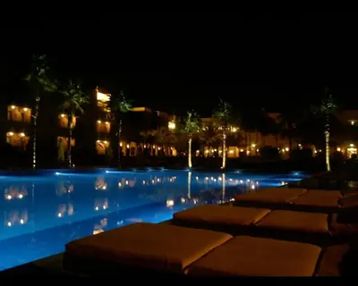 a row of umbrellas in a swimming pool at night at Villa Agdal in Marrakech