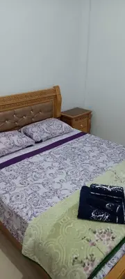 a bedroom with a bed with purple and green sheets at appartement Les Palmeraies in Marrakech