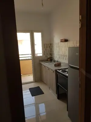 a small kitchen with a stove and a refrigerator at appartement Les Palmeraies in Marrakech