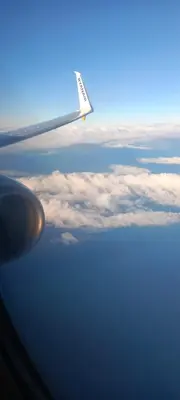 a view of the wing of an airplane flying over the ocean at appartement Les Palmeraies in Marrakech