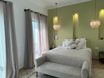 a bedroom with a bed and a chair and a window at Riad Belharra in Marrakech