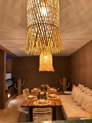 a dining room with a table and a chandelier at Riad Belharra in Marrakech
