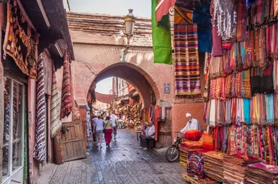 a group of people walking down a street in a market at Cosy Appart private riad jemaa el fna in Marrakech