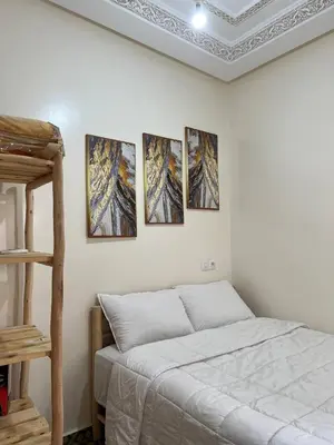 a bedroom with four pictures on the wall at Cosy Appart private riad jemaa el fna in Marrakech