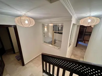 a hallway with two chandeliers and a mirror on the wall at The Majestic Marrakesh Duplex in Marrakech