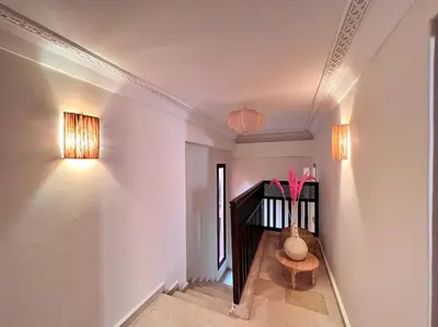 a hallway with a staircase with a vase with flowers in it at The Majestic Marrakesh Duplex in Marrakech