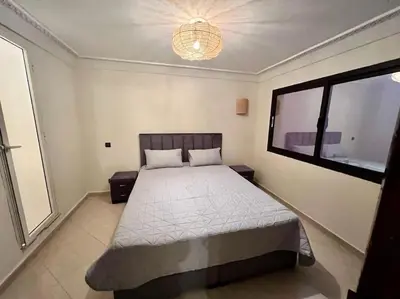 a bedroom with a bed and a large window at The Majestic Marrakesh Duplex in Marrakech
