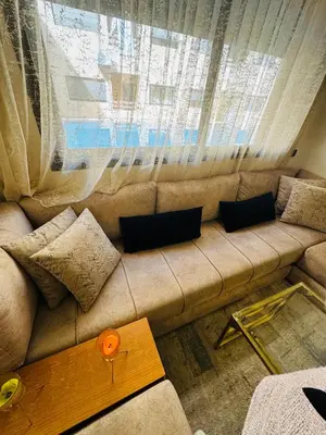 a couch with pillows sitting in front of a window at Glorieux appartement à gueliz in Marrakech